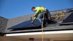 Residential solar PV panels installed by man on the roof